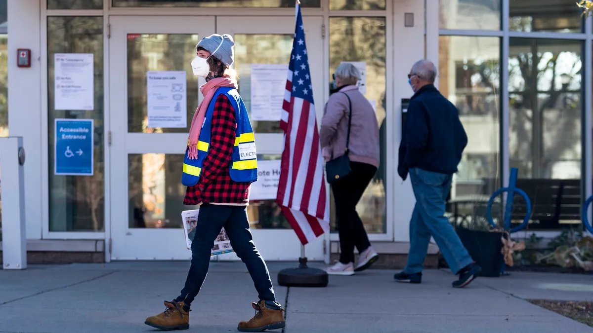 An election official outside and voters outside a voting location in Minneapolis, Minnesota.