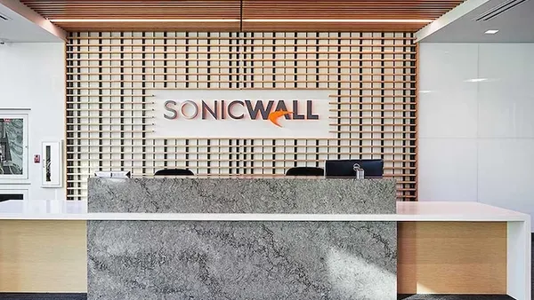 A lobby in a building with a desk and the company logo for SonicWall on the wall.
