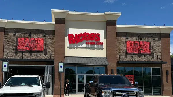 An image of a brown building with two trucks out front. Signage says Razzoo's Cajun CAfe