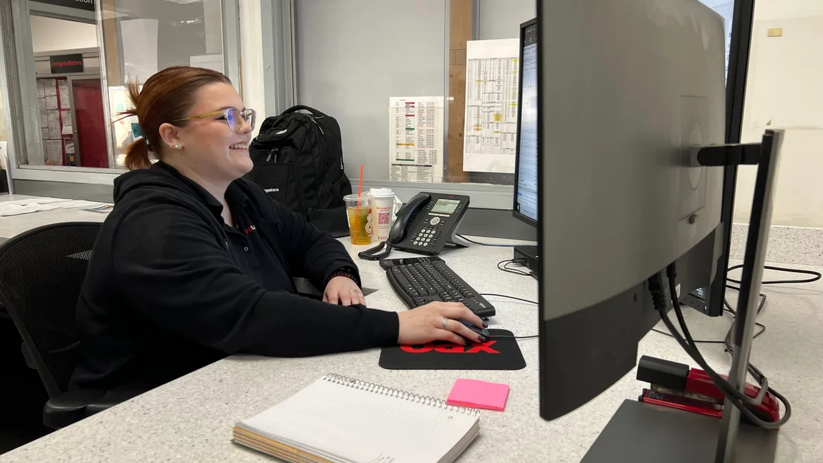 Kylee Garnett, freight operations supervisor at XPO's Hagerstown terminal, sits at a dual-monitor computer.