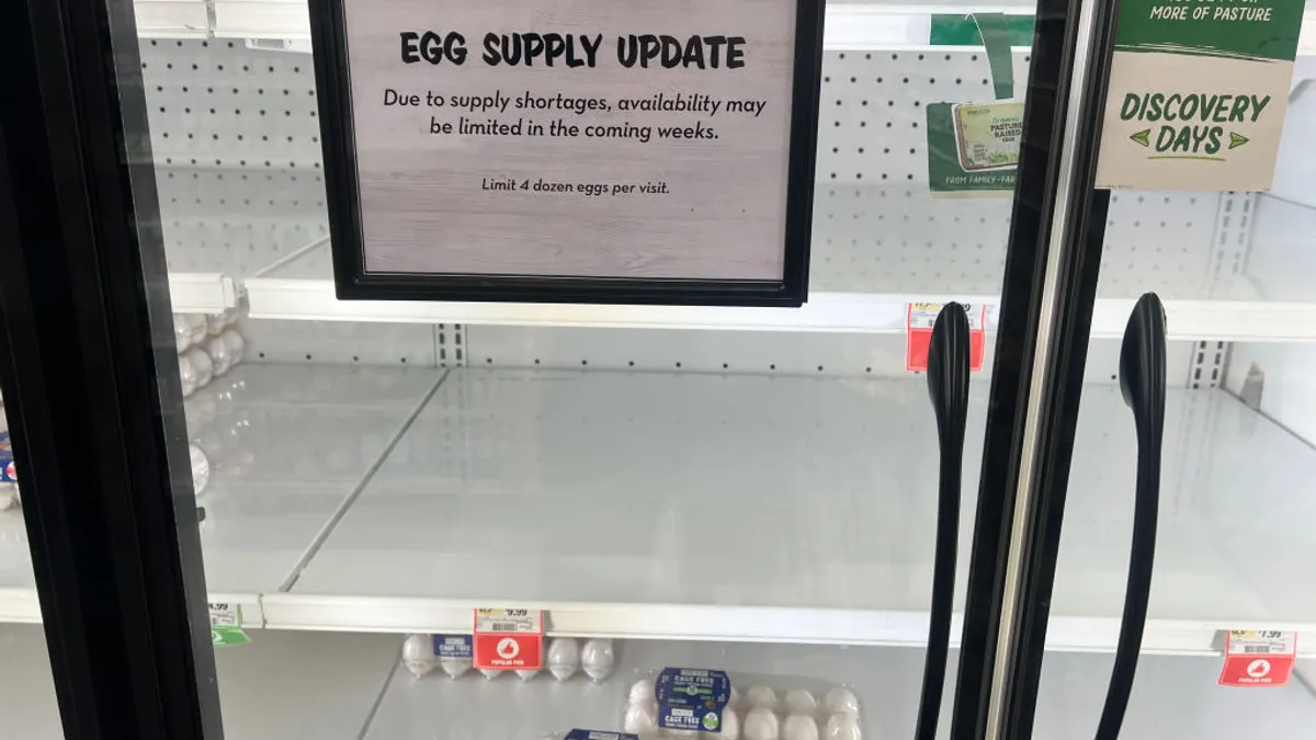 An egg display case is seen with a sign saying that supply shortages may impact product availability