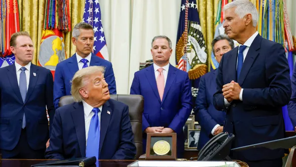 The president speaks to hotel executives in his office.