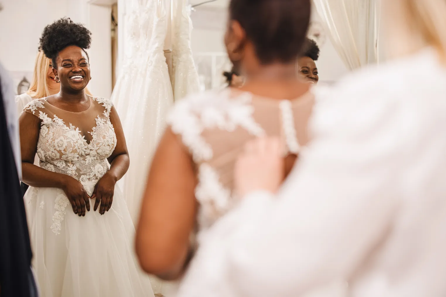 A bride tries on a dress at a store.