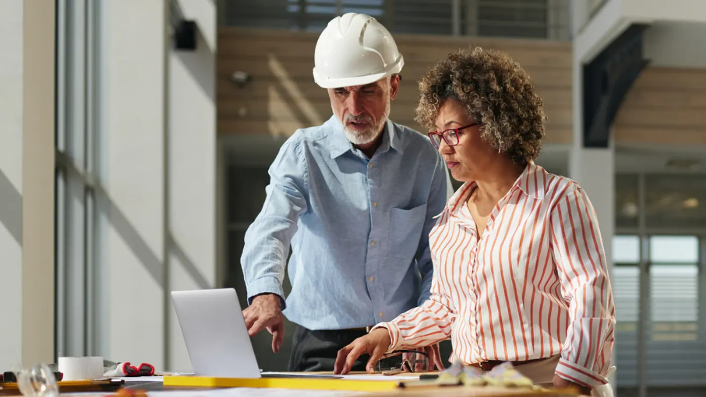 Construction personnel reviewing on a laptop