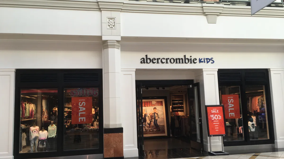 A white storefront with "Abercrombie Kids" on it and sale signs out front.