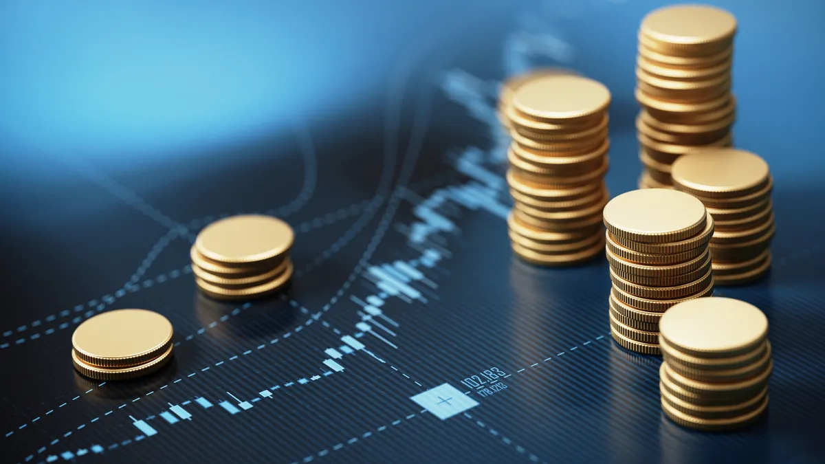 Coin stacks sitting on blue financial graph background. Horizontal composition with selective focus and copy space.