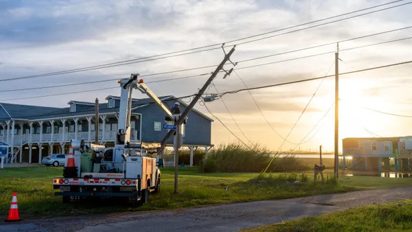 A utility worker works to restore a damaged power-line.
