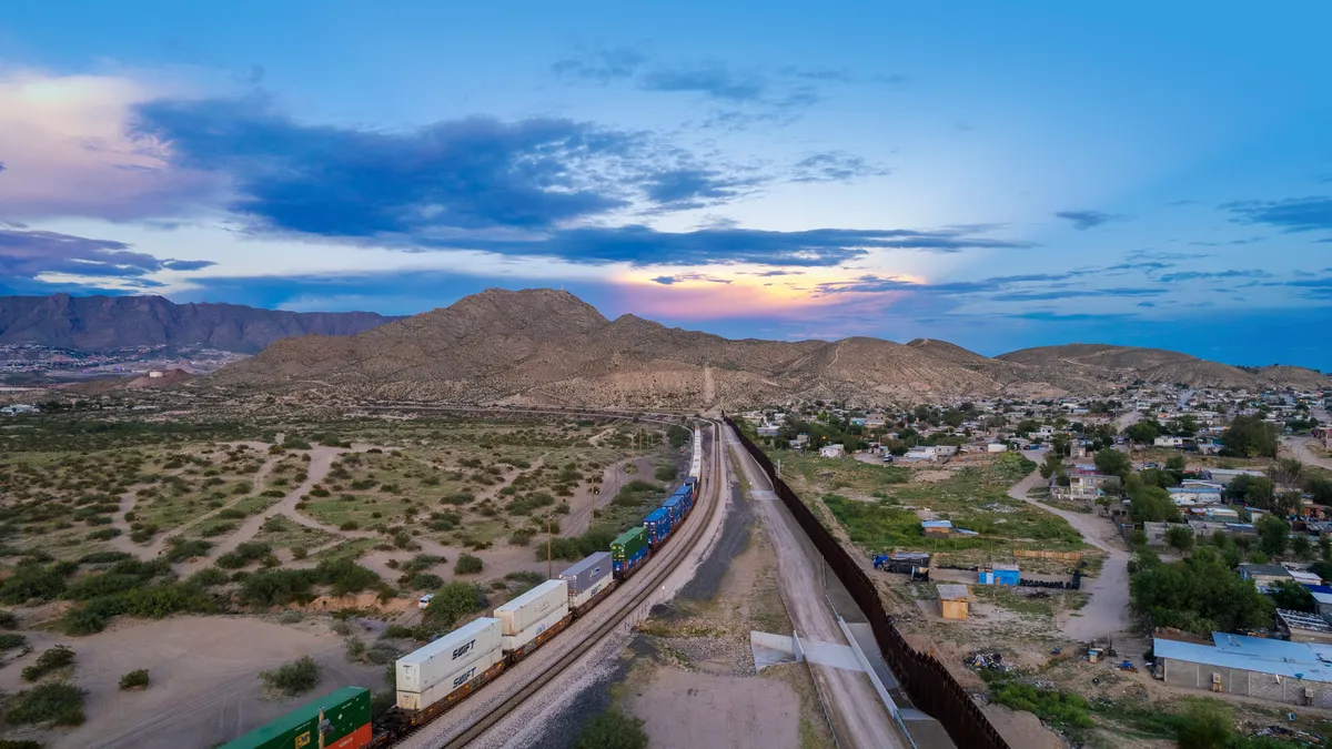 A drone view of a train passing alongside Puerto de Anapra town at the border between USA and Mexico.