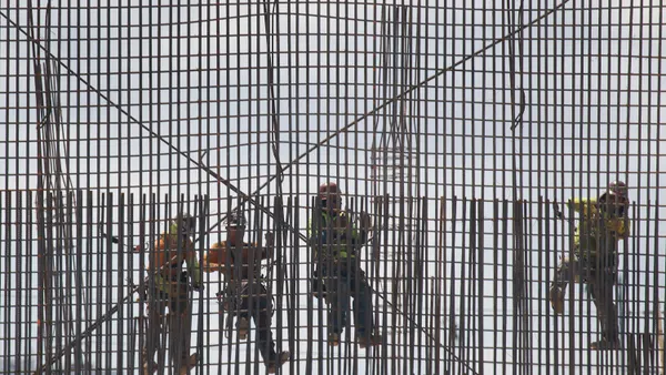 Construction workers are seen as they work with steel rebar during construction