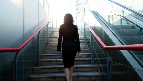 businesswoman climbing up the stairs; career progression concept