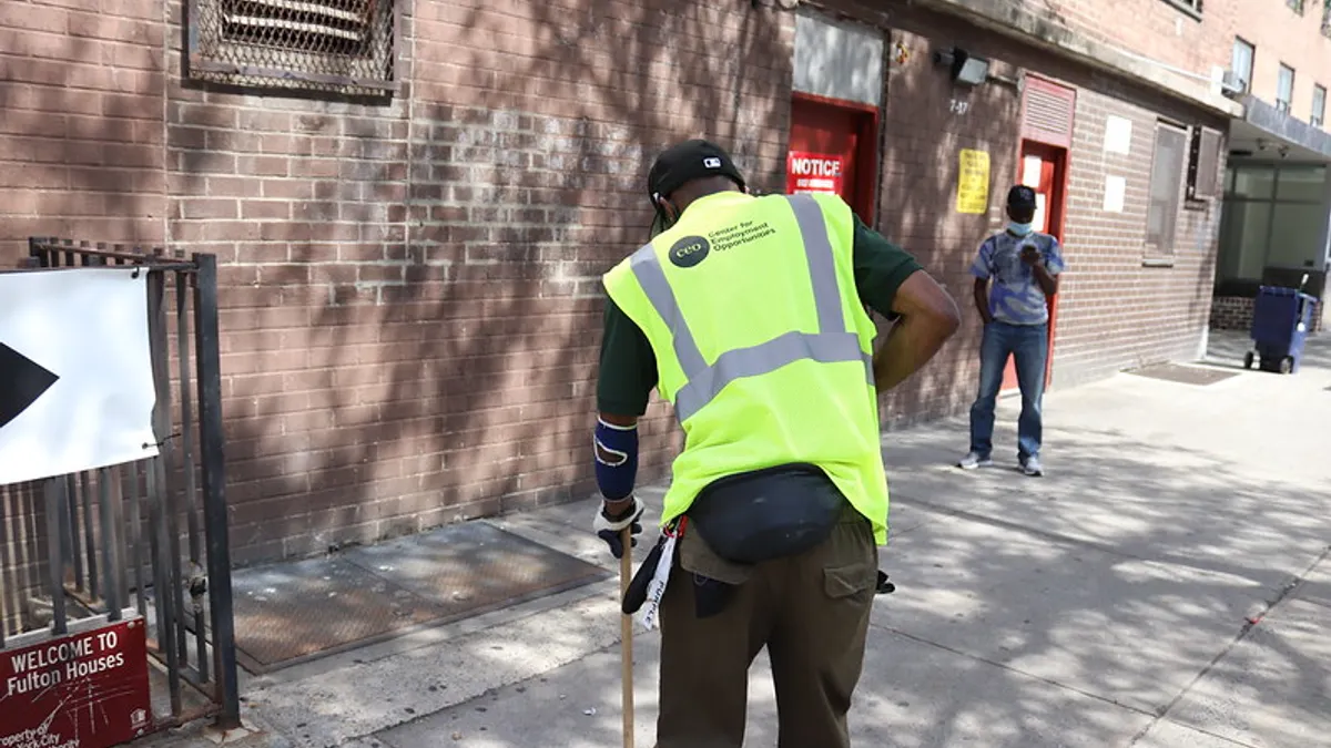 Center for Employment Opportunities worker sweeps New York City street