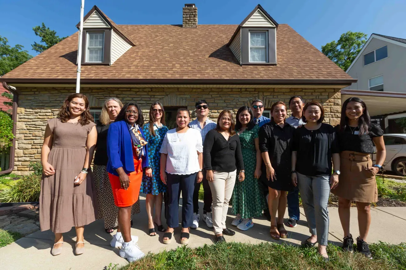 Topeka Public Schools Superintendent Tiffany Anderson stands with international teachers in front of a home.