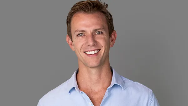 A person smiles and poses for a professional photo.