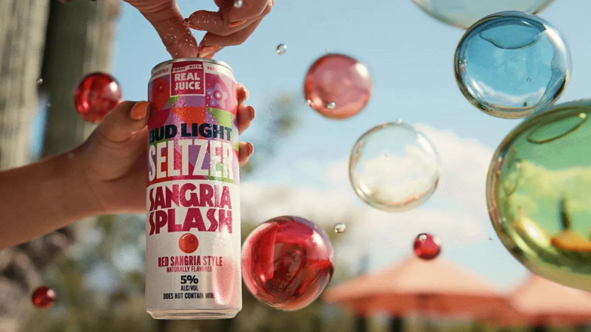 A hand cracks open a can of Bud Light Seltzer against a background of colorful bubbles.