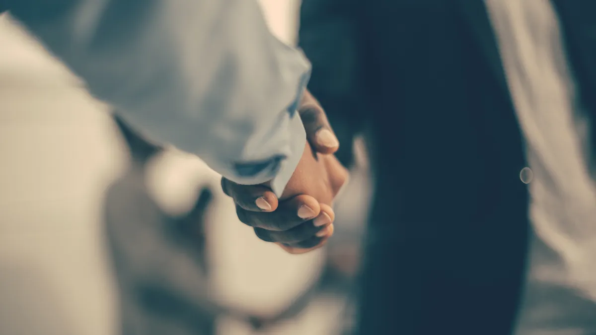 Two people shake hands.