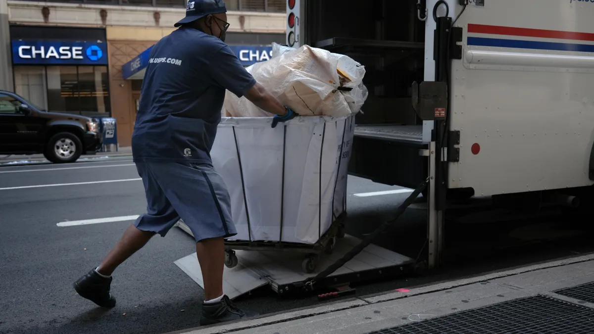 A United States Postal Service (USPS) carrier makes his rounds on August 05, 2020 in New York City.