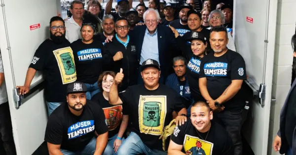 A group of workers wearing shirts that say "Mauser Teamsters" pose with Sen. Bernie Sanders, I-Vt.