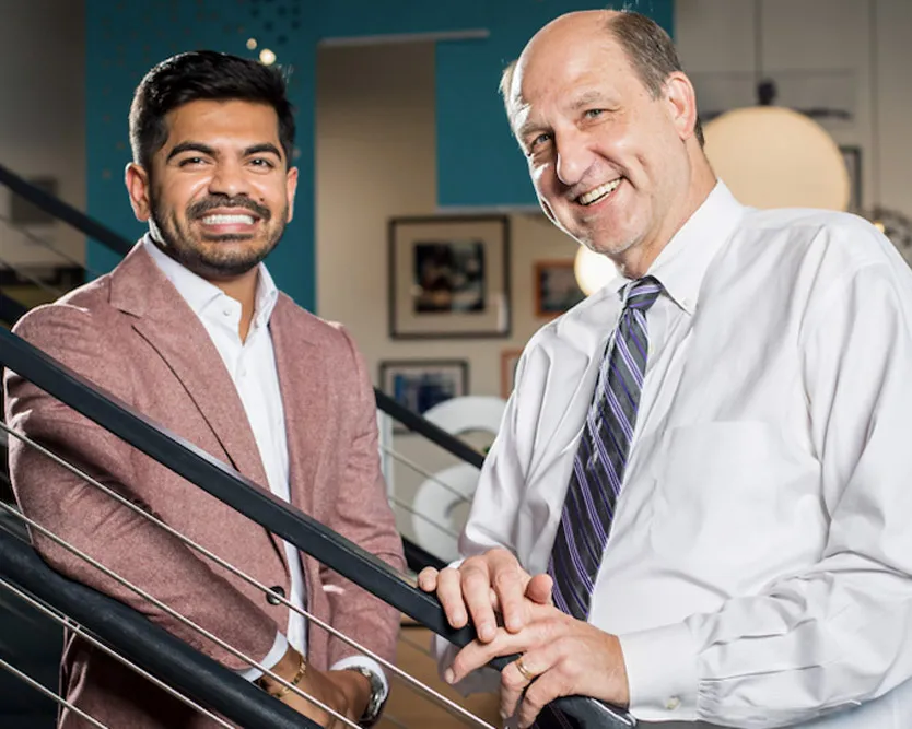 Two individuals, Mountain Express’ former co-CEOs, standing on a stairway for a portrait.