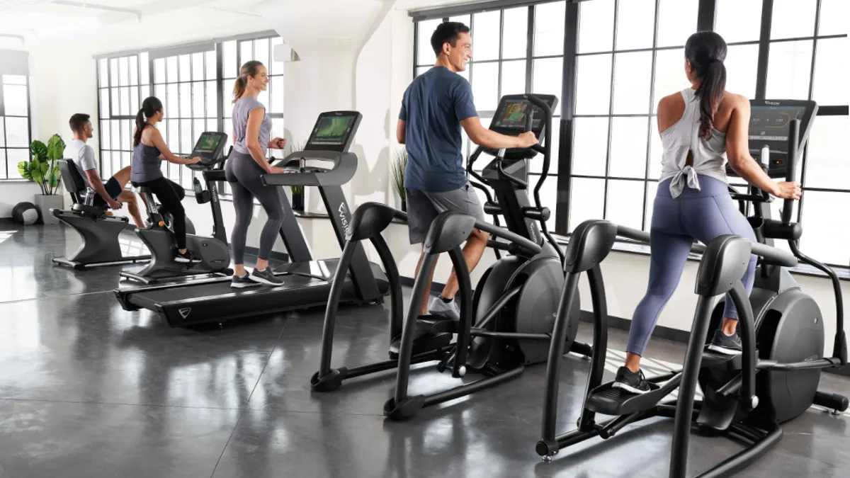 People working out on workout equipment in a gym.