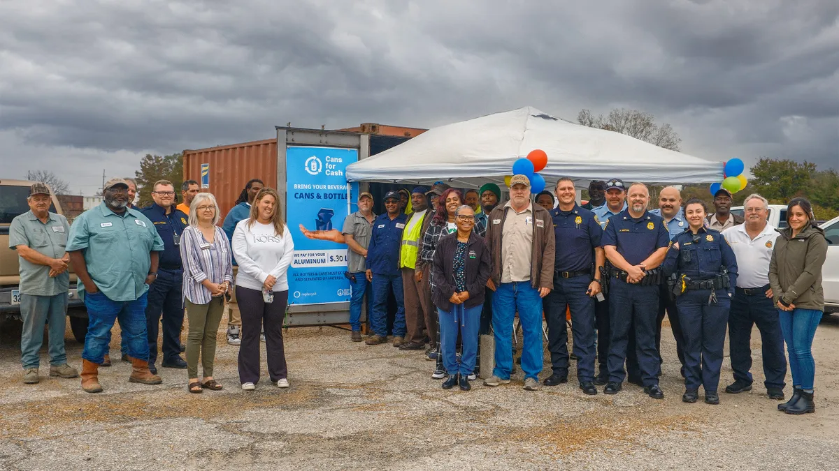 A group stands next to a recycling drop-off point