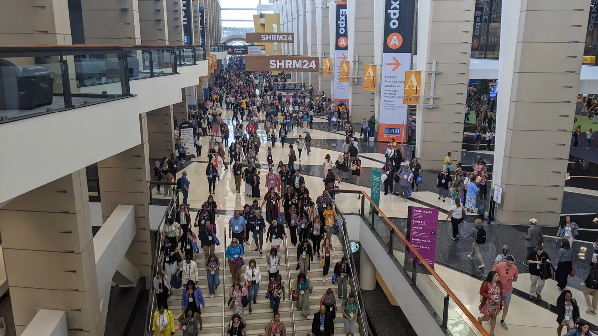 Individuals walk through a conference hall.