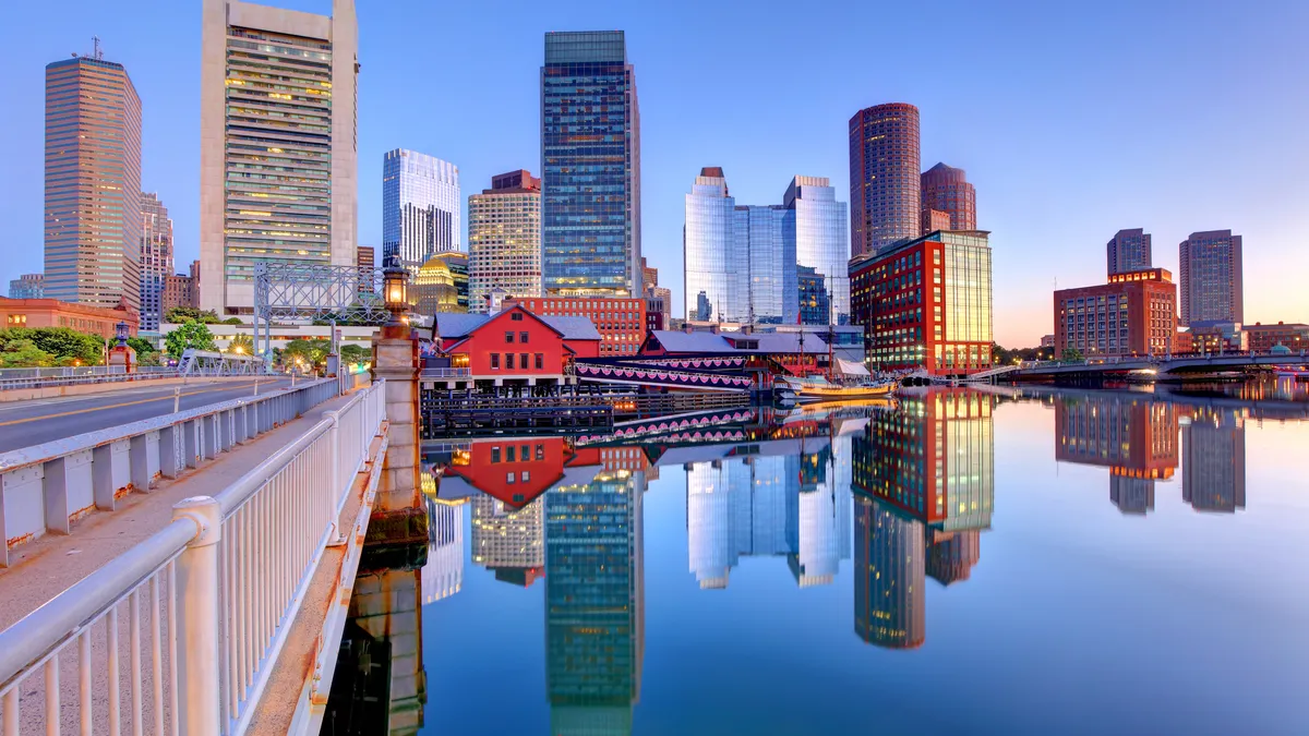 city landscape image of tall buildings in Boston with a river in front