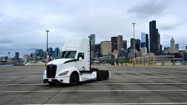 An electric truck parked sideways in a parking lot.