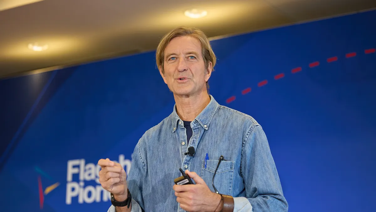 John Mendlein, an executive partner at Flagship Pioneering, speaks in front of a blue background at a company summit.