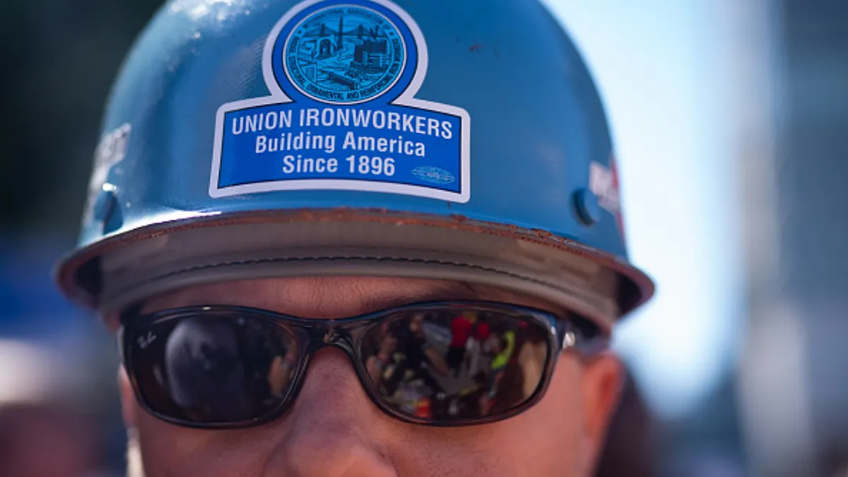 A close-up of a construction worker and his hard hat.