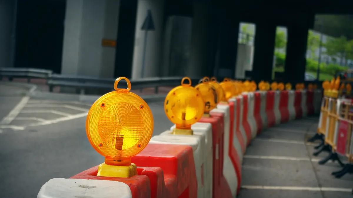 Construction barrels sit next to a highway work zone