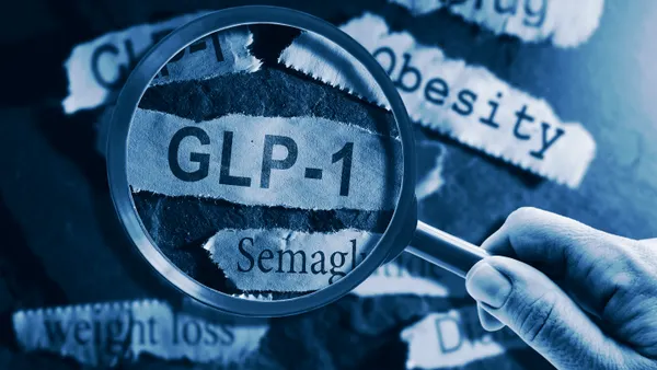 GLP-1 related drugs newspaper headlines with hand and magnifying glass