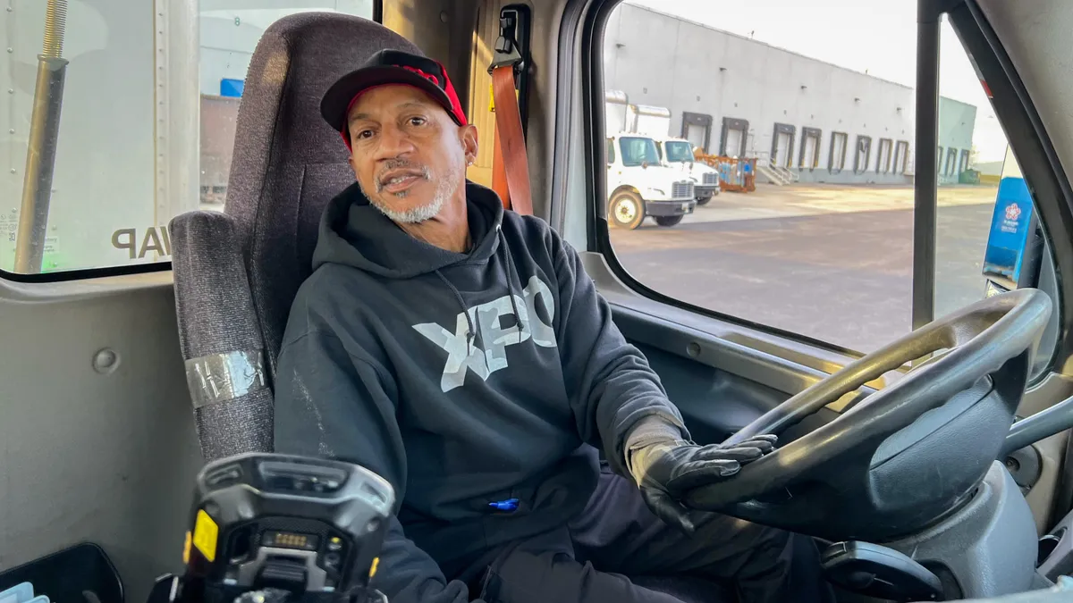 XPO driver Steadman "Steve" Mitchell reverses his truck toward a loading dock at a customer facility in Maryland on Feb. 27, 2024.