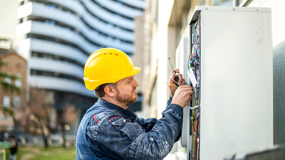Technician services an outdoor electric panel.