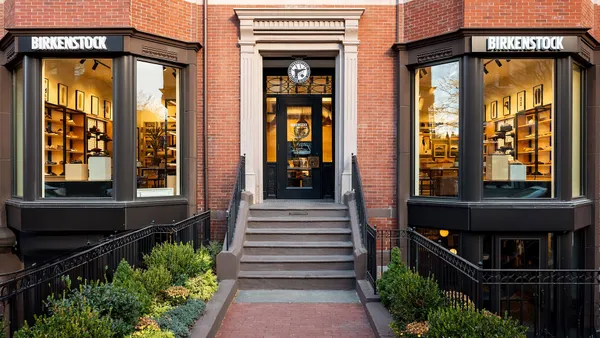 A brick building displays two windows with "Birkenstock" above them and a front door.