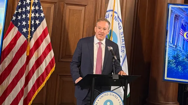 Lee Zeldin speaks at a podium, with the American flag seen to the left.