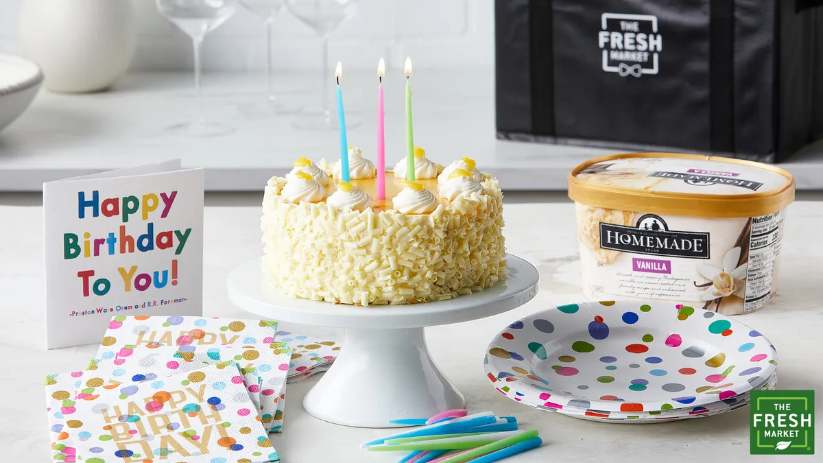 Birthday cake, card and ice cream on a table.