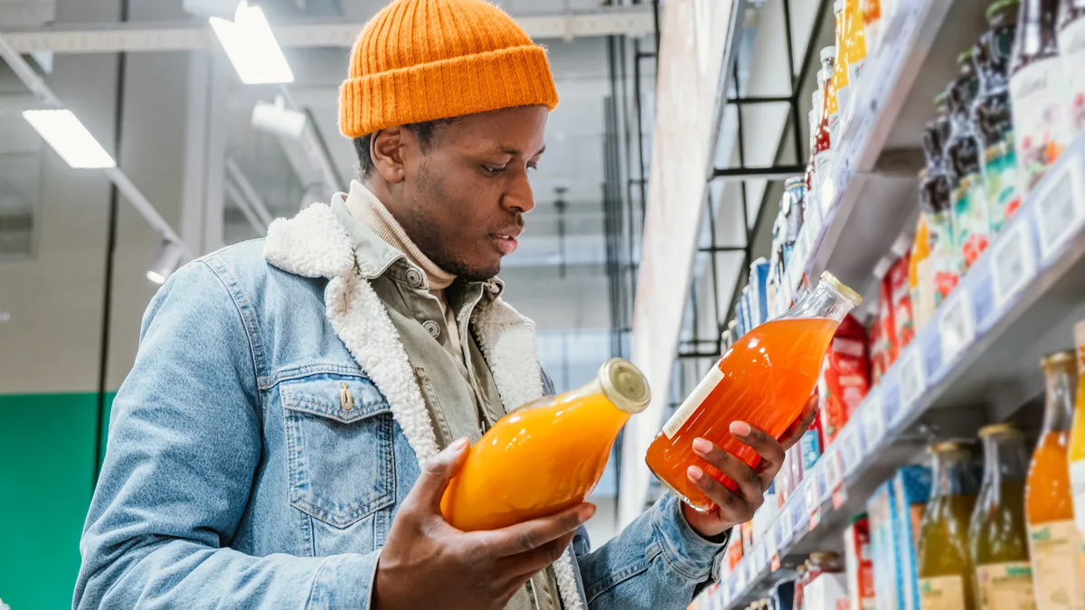 A shopper compares two bottles of juice.