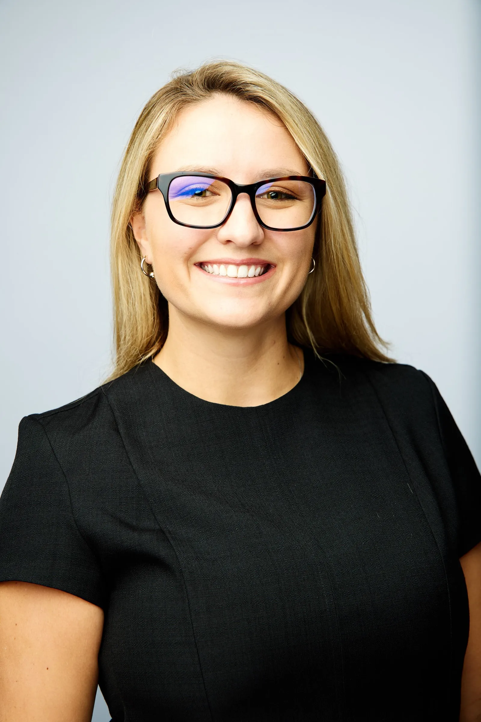 Taylor Farris, who works at Bank of America, wears a black outfit and glasses