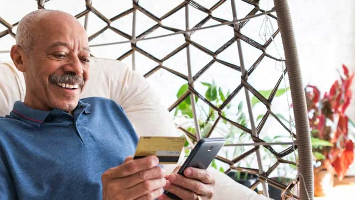 Man entering credit card information online through mobile phone