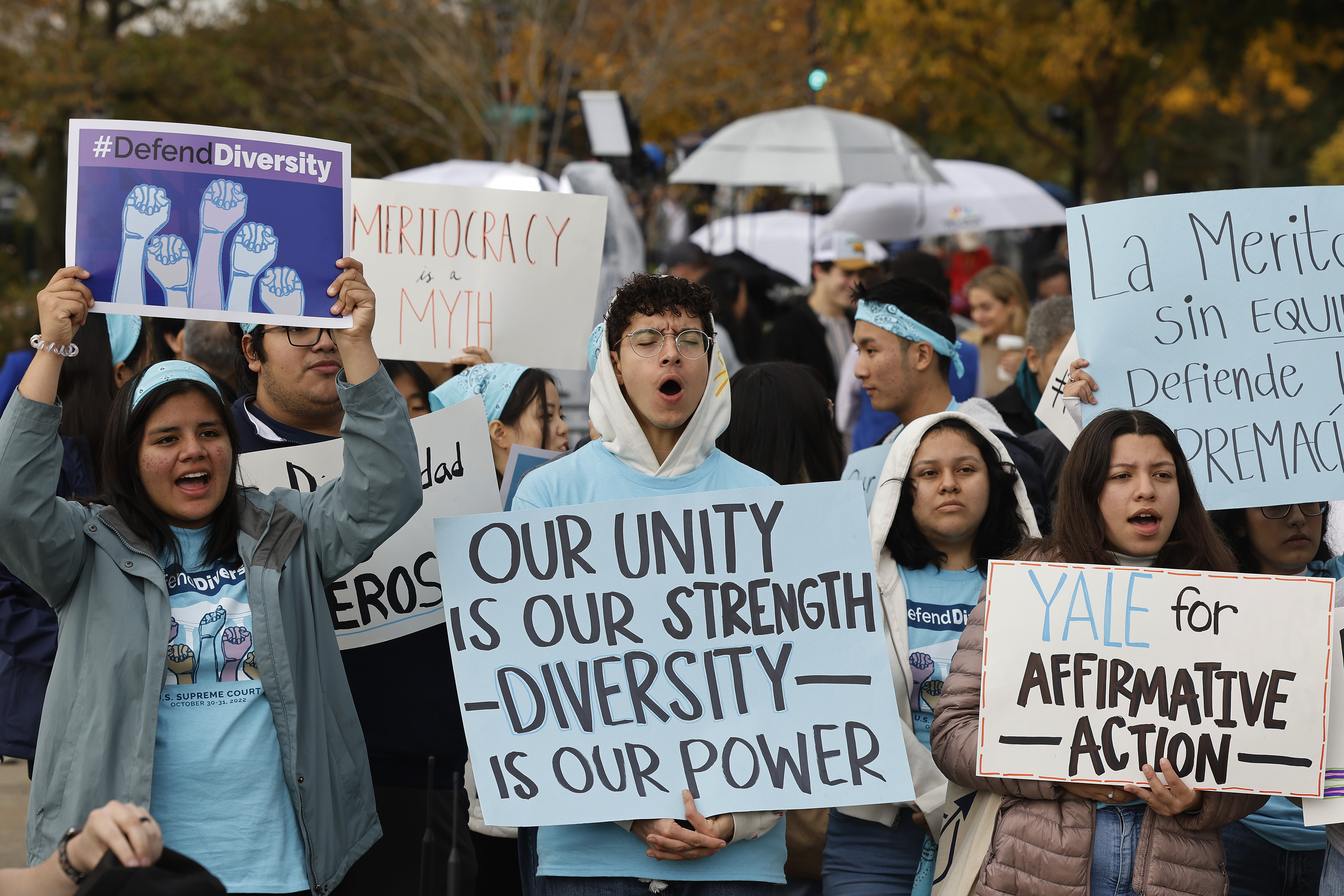 A group of protesters stands with signs calling for the U.S. Supreme Court to back race-conscious admissions.