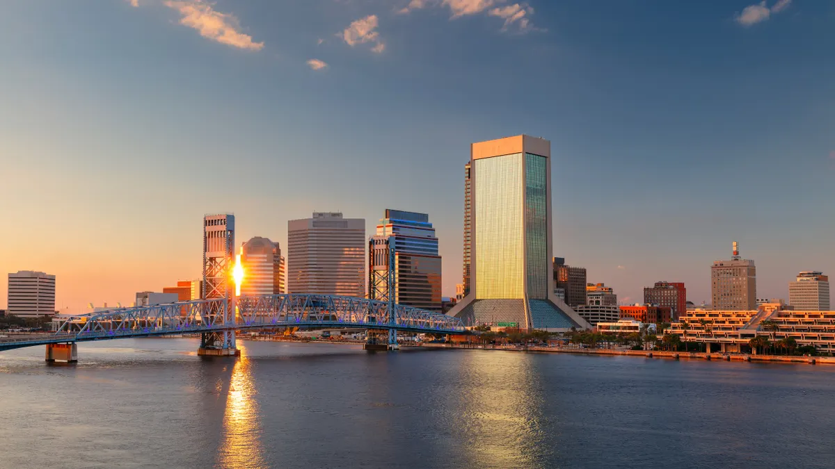 A skyline of buildings and a bridge over a body of water.