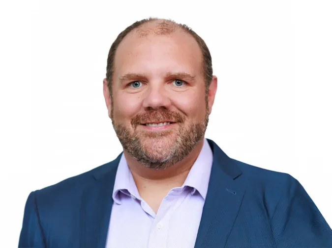 A head and shoulders photo of a person standing against a white background.