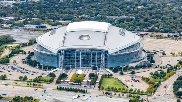 Aerial view of large enclosed stadium lettered "AT&T Stadium"