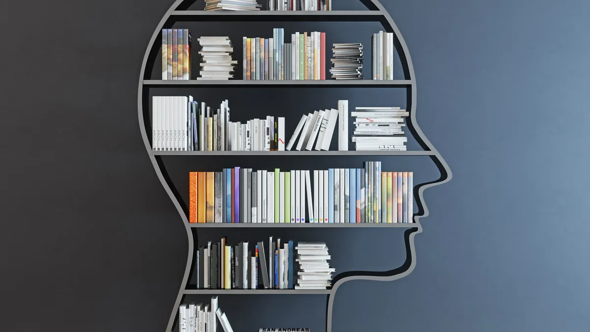 head shaped bookshelf filled with books on black background