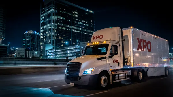 An XPO truck drives at night.