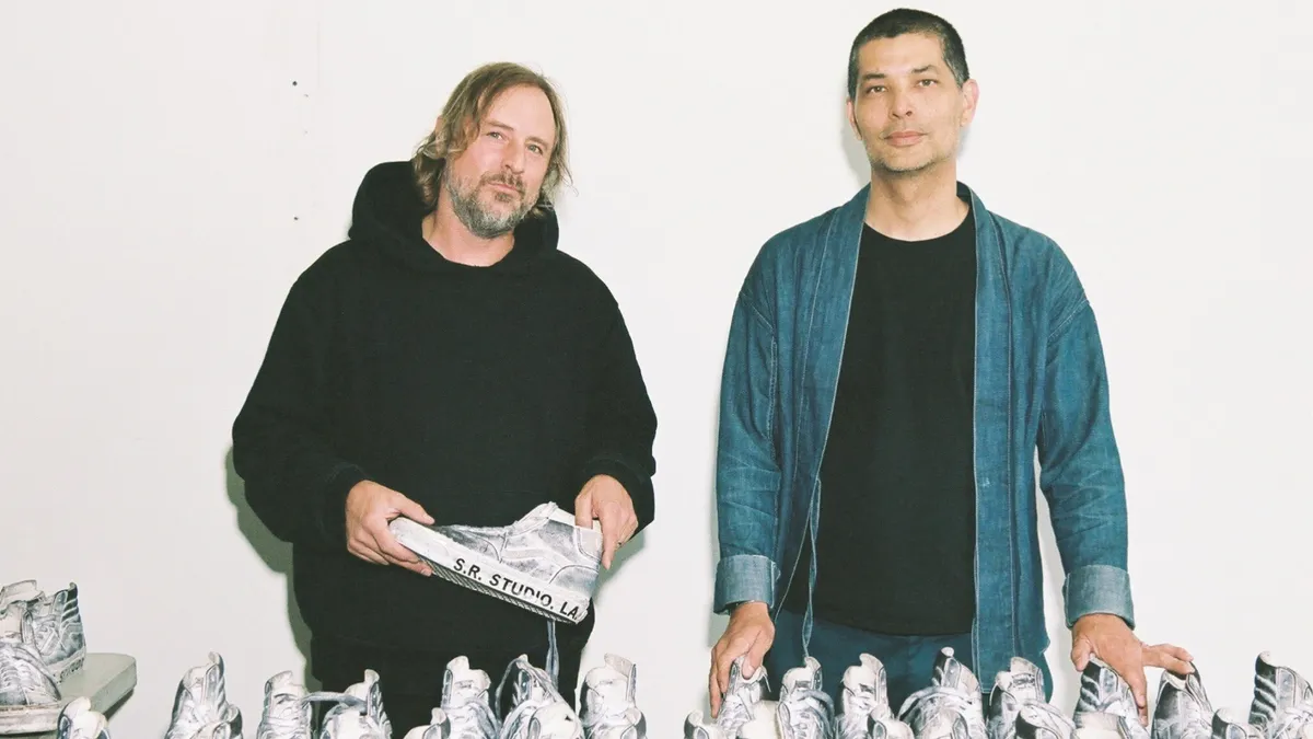 Sterling Ruby and Ian Ginoza stand in front of a table of Vans sneakers.