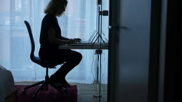 A person types on a computer in a home office.