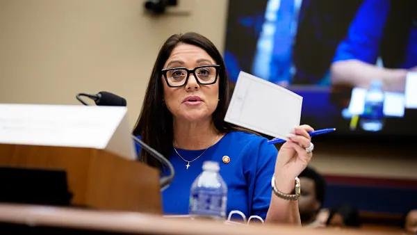A woman sitting in front of a microphone and speaking.