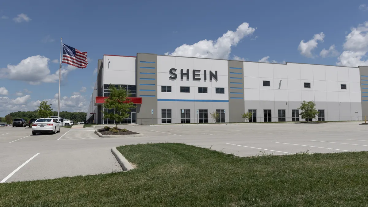 A Shein building is seen across a parking lot, with an American flag to its side.