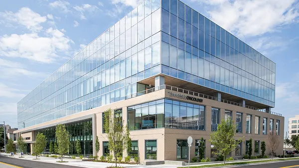 A photo shows a medical office building on a sunny city street.
